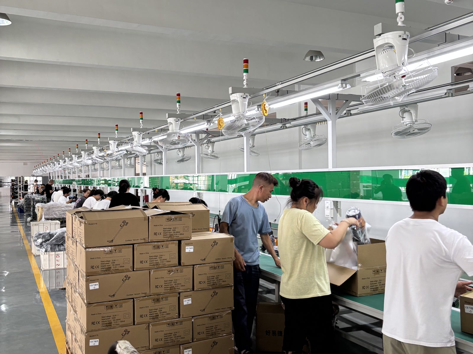 Workers assembling and packing cordless vacuum cleaners at the LuxVac factory
